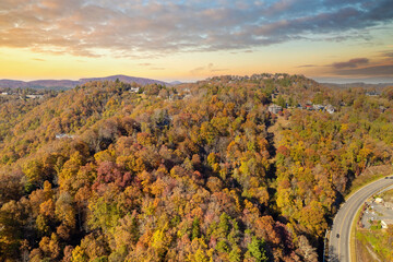 Obraz premium Rural houses between golden woodlands of North Carolina in fall season. Appalachian mountains with dense forest canopies.