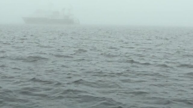 Arctic Ocean Ship Crossing Remote Polar Waters Along Polar Horizon. Dark swells move across the cold water while the distant polar horizon remains clearly visible.