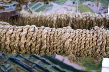 Braided ichu grass rope tied to a suspension bridge with blurred agricultural terraces in the background © WILL PHOTOGRAPHY
