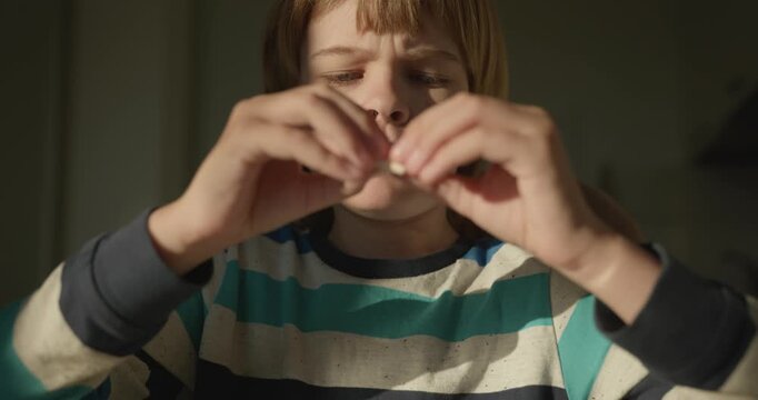 Close-up kid boy eats breakfast lunch in kitchen. 4K 10-bit
