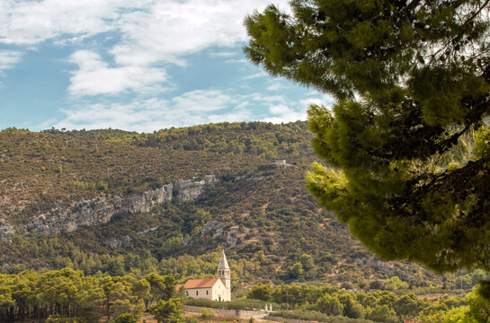 Stone Church Surrounded by Pine Forest and Rocky Hills