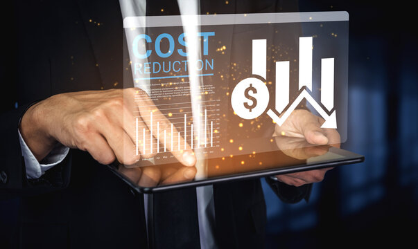 A businessman in a formal suit is analyzing cost reduction strategies on a tablet, showcasing financial graphs and icons, symbolizing modern business practices and data analysis. Ledger