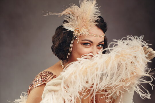 Playful 1920s Flapper Woman Peeking Behind Feather Boa - Great Gatsby Style