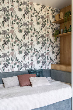 Cozy room interior with daybed and tropical botanical wallpaper