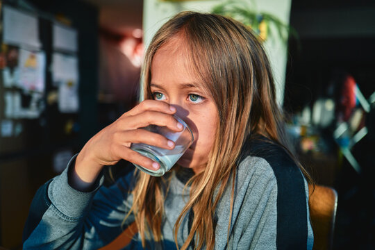 Boy Drinking a Glass of Milk at a Kitchen Table