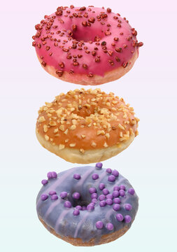 Three different levitating donuts with colored glaze, nut and berry sprinkles