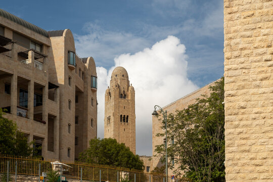 Jerusalem, Israel, 26 September 2026. YMCA tower rises between Jerusalem stone buildings beneath dramatic white clouds and blue sky.