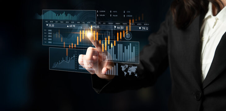 A businesswoman engages with a digital financial data interface, analyzing stock market trends and performance metrics in a contemporary workspace atmosphere. Scalp