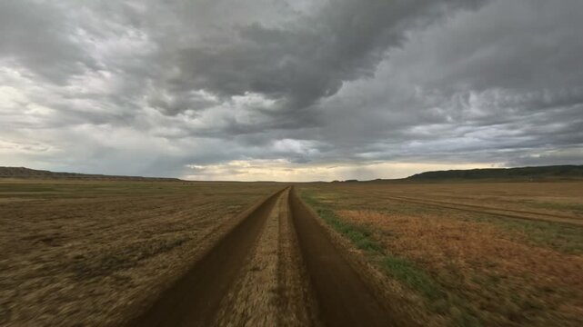 Forward tracking shot along a dirt track in an arid plain