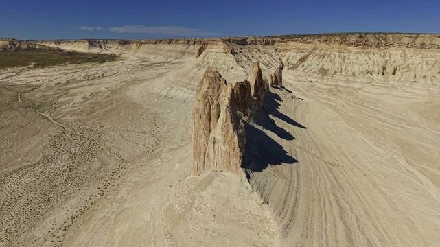 Aerial pull back from eroded rock spires in desert