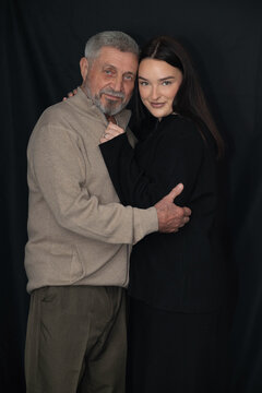 Older man embracing his granddaughter in a tender family portrait. The intimate moment represents intergenerational love, trust, emotional connection, and a strong family bond.
