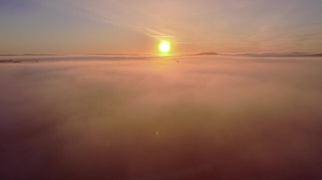 Rising and flying through clouds to sky above the sunrise to see the landscape 