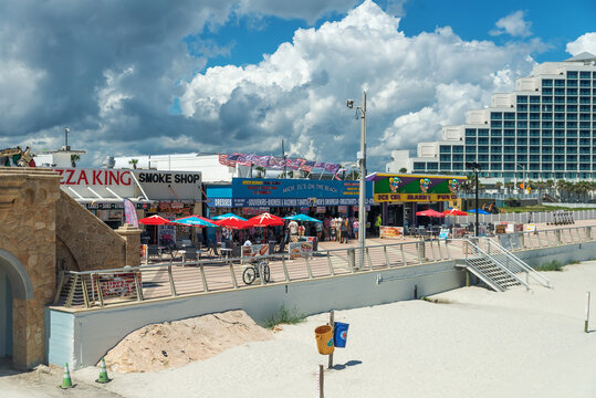 Bright signs advertise shops and food along the Daytona Beach waterfront promenade.
