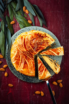 Classic traditional artisan homemade French galette des rois - three kings cake served as top view on a design plate on a wooden board table