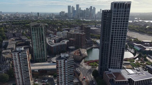 Aerial view of Canada Water, London, showcasing residents and commuters near the station hub, with distant Canary Wharf.
