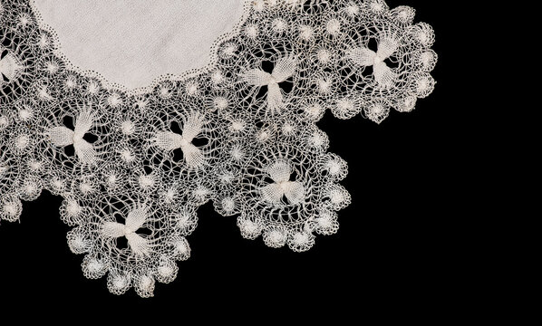 Tenerife lace, needle lace antique traditional doily also known as Spanish Sol Lace embroidery, whitework, white work, needlework. Isolated on black background, border art design, top view, vintage. 