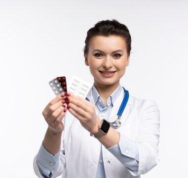 Attractive woman qualified specialist therapist wear white doctor robe hand hold pills isolated on white background.