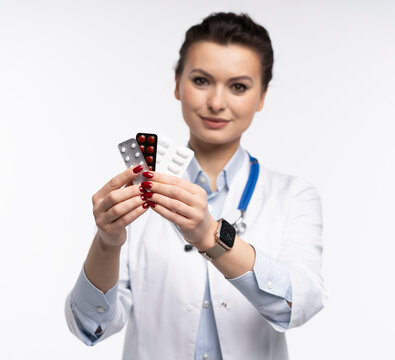 Attractive woman qualified specialist therapist wear white doctor robe hand hold pills isolated on white background.
