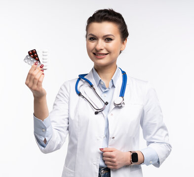 Attractive woman qualified specialist therapist wear white doctor robe hand hold pills isolated on white background.