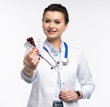 Attractive woman qualified specialist therapist wear white doctor robe hand hold pills isolated on white background.
