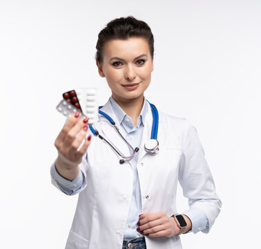 Attractive woman qualified specialist therapist wear white doctor robe hand hold pills isolated on white background.