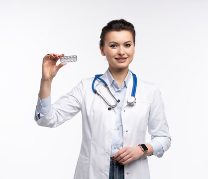 Attractive woman qualified specialist therapist wear white doctor robe hand hold pills isolated on white background.