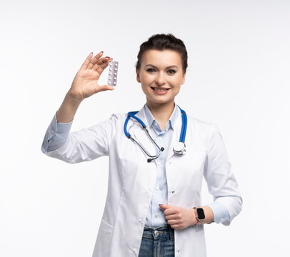 Attractive woman qualified specialist therapist wear white doctor robe hand hold pills isolated on white background.