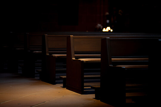 Light touches empty church pews in quiet space