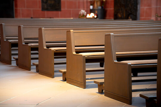 Rows of wooden benches in a quiet church interior