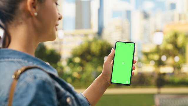 Vertical green screen chroma key on mobile phone held by woman