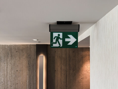 Panneau de sortie de secours sur le mur d'un couloir d'h&ocirc;tel, gros plan. Panneau indiquant la sortie de secours.