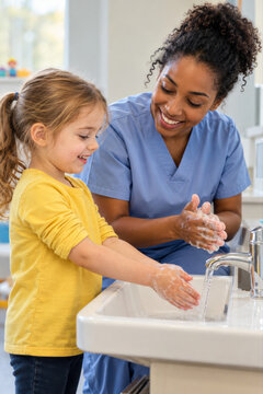 Eine Pflegekraft w&auml;scht gemeinsam mit einem Kind die H&auml;nde und zeigt spielerisch die richtige Hygiene. Die f&uuml;rsorgliche Begleitung f&ouml;rdert Gesundheit, Selbstst&auml;ndigkeit und Vertrauen im Pflegealltag.
