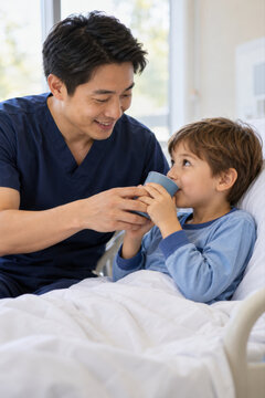 Ein Pfleger hilft einem Jungen behutsam beim Trinken und achtet auf sein Wohlbefinden. Die pers&ouml;nliche Unterst&uuml;tzung zeigt f&uuml;rsorgliche Kinderpflege und menschliche Zuwendung im Krankenhausalltag.