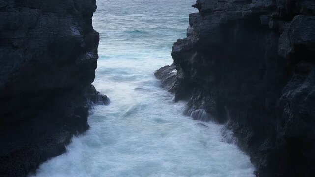 岩の割れ目で波同士がぶつかる シームレスループ動画背景 16:9 4K