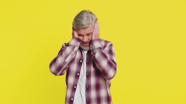 Caucasian middle-aged man on yellow background showing powerless frustration, hopeless stress, depression. Angry mature guy tension desperate emotional turmoil despair rage nervous negative expression