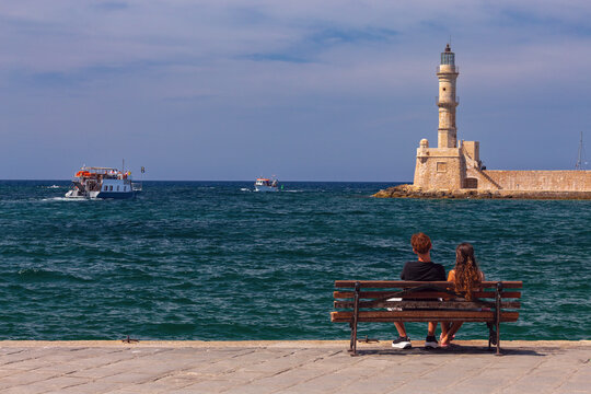 Title EN: Couple Watching Chania Lighthouse from Waterfront, Crete, Greece