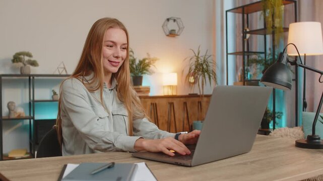 Happy businesswoman freelancer working on laptop at home office desk talk on online communication video call with employee, boss. Manager girl support services looking wave hand at webcam of computer.