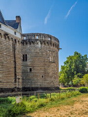 Obraz premium Nantes, France, Europe - August 7, 2026: Château des ducs de Bretagne, Castle of the Dukes of Brittany. Bastion or circular defensive tower along the ramparts with Battlement and parapet on topMoat un