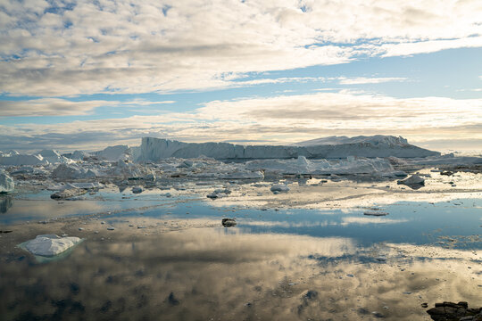 Iceberg and ice from glacier in arctic nature landscape on Greenland. Aerial photo drone photo of icebergs in Ilulissat icefjord. Affected by climate change and global warming