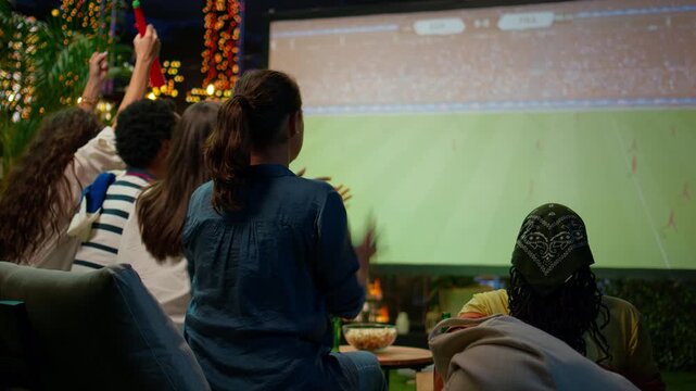 Impatient football supporters react negatively to a projected game on an outdoor lounge screen as passionate spectators feel stress at the rooftop watch party.