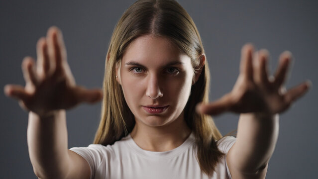 Young woman reaching hands with strong willpower and concentration