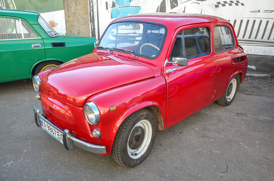 Bright red ZAZ-965 "Humpback" Zaporozhets microcar showcasing round headlights, suicide doors, and rear-engine vents, highlighting iconic Soviet classic car culture