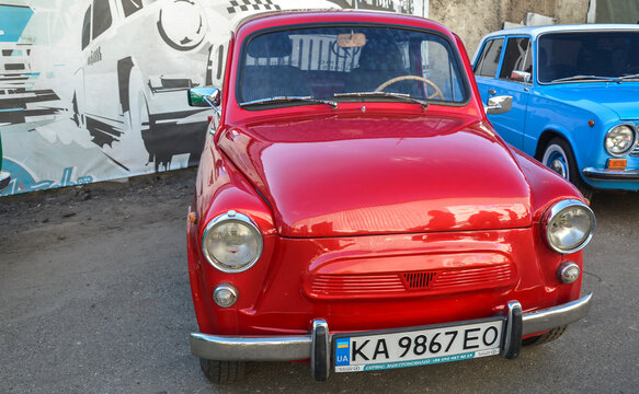 Bright red ZAZ-965 "Humpback" Zaporozhets microcar showcasing round headlights, suicide doors, and rear-engine vents, highlighting iconic Soviet classic car culture