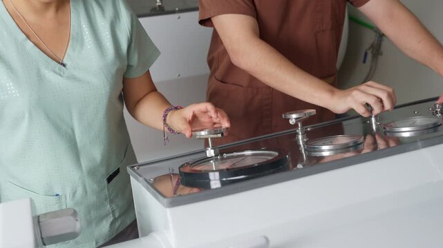 Medical staff closing hyperbaric chamber for oxygen therapy session