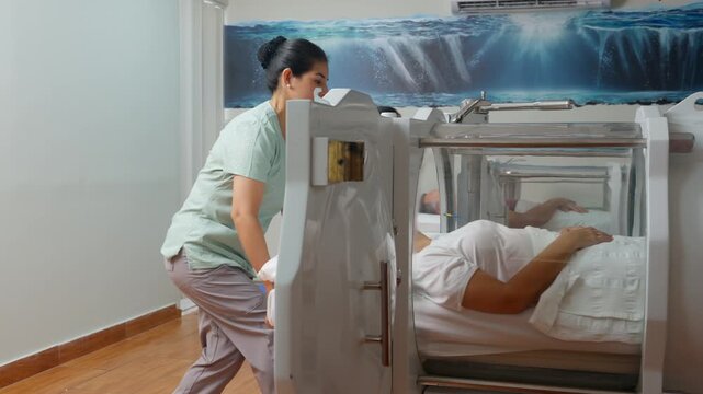 Nurse assisting patient into hyperbaric oxygen therapy chamber