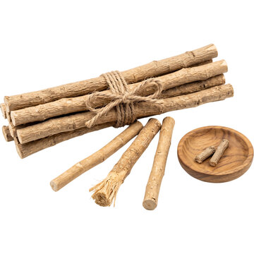 Bundle of natural miswak chewing sticks tied with twine, loose sticks with a frayed bristle end and a wooden dish, traditional oral care
