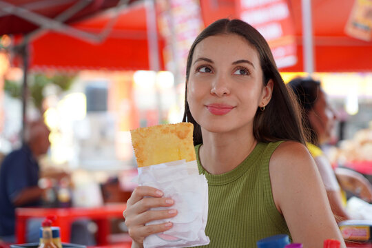 Young Woman Holding Brazilian Pastel de Feira in Liberdade Japanese Neighborhood of Sao Paulo, Brazil