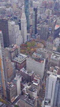 Vertical video: Construction crane on a skyscraper in Midtown Manhattan, near iconic buildings including MetLife Building is skyscraper at Park Avenue and 45th Street