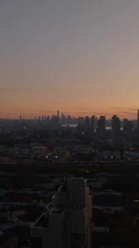 Vertical video: Aerial views capture Long Island City's modern architecture at dusk, with Manhattan island and East River background, enhancing New York City skyline