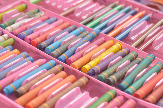 Colorful oil pastel crayons and colored pencils arranged in a stationery set box
